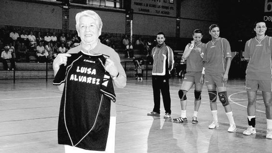 Luisa Álvarez Iglesias, en el polideportivo de Laviana con una camiseta que pone su nombre, y varias jugadoras detrás.