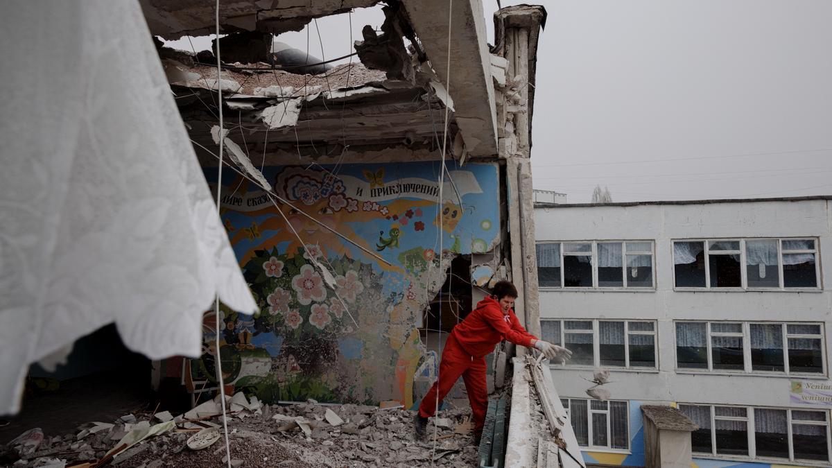 Una mujer retirando los escombros de un edificio bombardeado en la ciudad de Jarkiv.