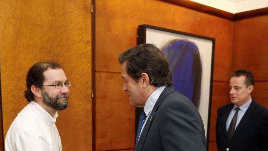 Emilio León, a la izquierda, y Javier Fernández se saludan antes de la reunión. Detrás, Marcelino Marcos Líndez.