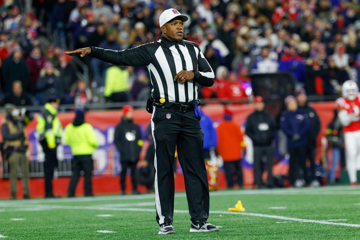 Un árbitro principal de la NFL lanza el pañuelo amarillo para señalar una infracción durante un partido de la liga.