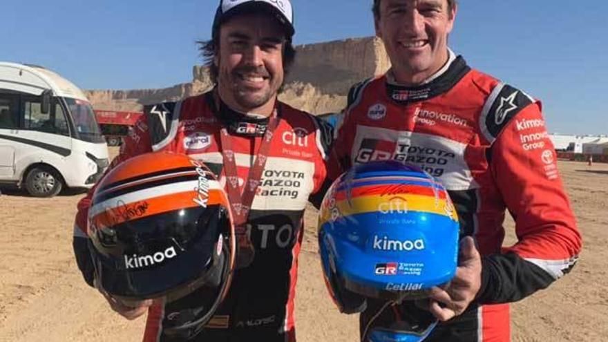 Fernando Alonso y Marc Coma, tras intercambiarse sus cascos al final del Rally Dakar.
