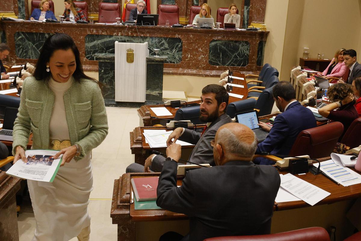 Virginia Martínez se dirige a su escaño  bajo la mirada de Antelo tras una  comparecencia en el Pleno de la Asamblea.