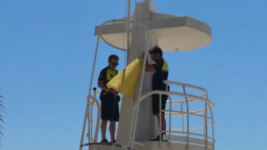 Agentes de Policía Local colocan la bandera en una playa