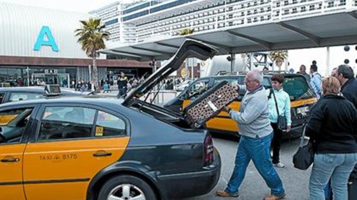 Un taxista carga equipaje en el muelle Adossat, el pasado abril.