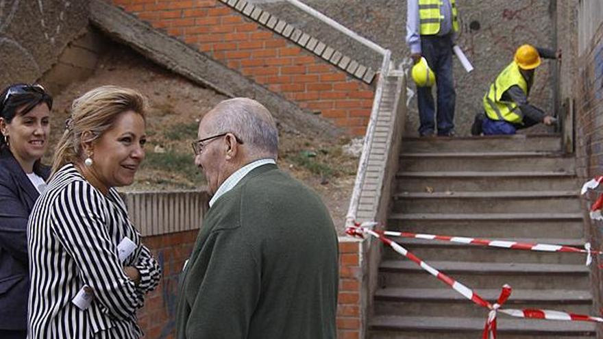 Rosa Valdeón, en primer término, comenta las obras con un vecino de la zona.