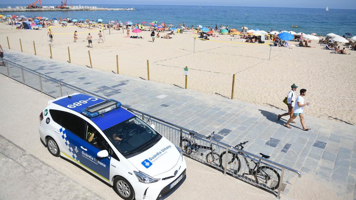 Un coche de una patrulla de la Guardia Urbana en la playa de la Nova Icària, en Barcelona.