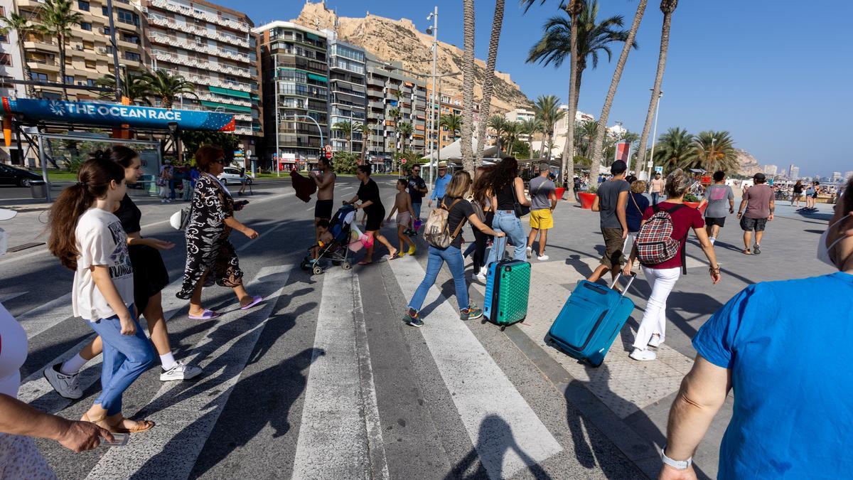 Turistas con maletas caminando hacia el Paseo de Gómiz en Alicante