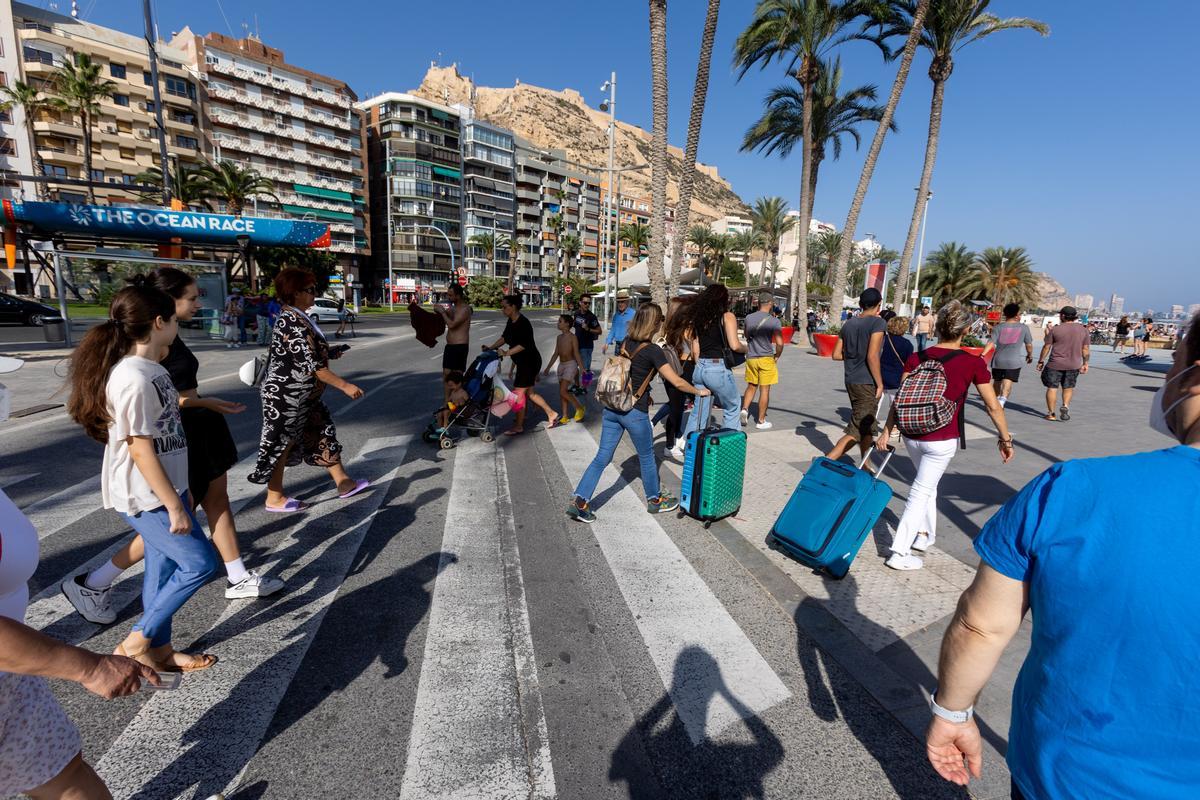 Turistas con maletas caminando hacia el Paseo de Gómiz en Alicante