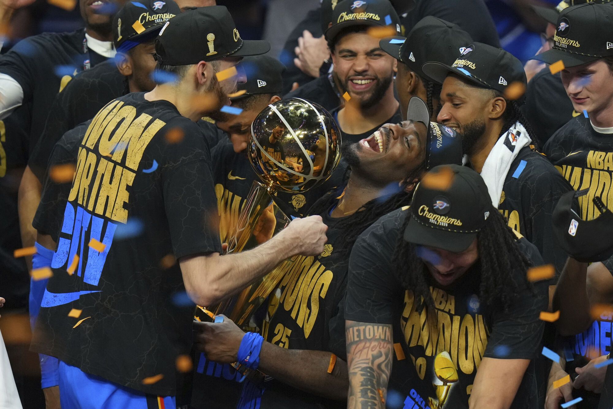 Oklahoma City Thunder guard Luguentz Dort, center, holds the Larry O'Brien Championship Trophy as he celebrates with his team after they won the NBA basketball championship with a Game 7 victory against the Indiana Pacers Sunday, June 22, 2025, in Oklahoma City. (AP Photo/Nate Billings)