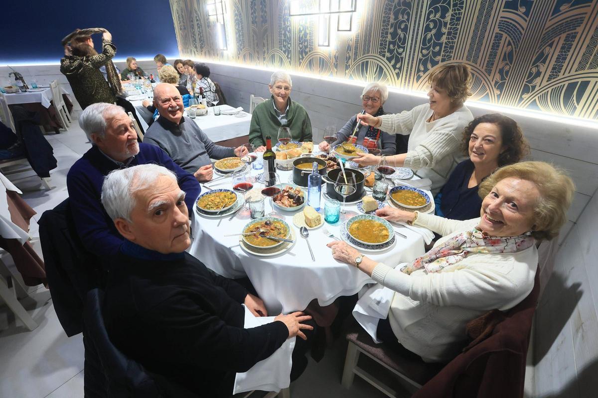 Comensales disfrutando de un plato de pote en una imagen de archivo
