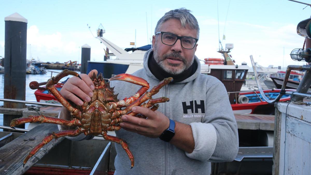 Un marinero en Bueu con una centolla en su barco.