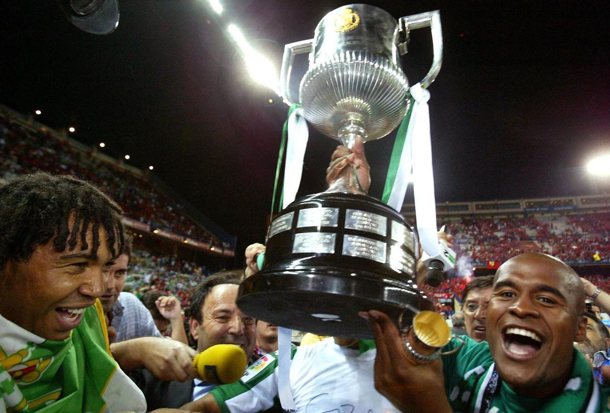 MADRID 11/06/05.- Los jugadores del Real Betis, Benjamín (i) y Assunçao (d) levantan el trofeo tras imponerse 2-1 a Osasuna en la final de la Copa del Rey disputada esta noche en el estadio Vicente Calderón, en Madrid. EFE/B. Echavarri. FUTBOL