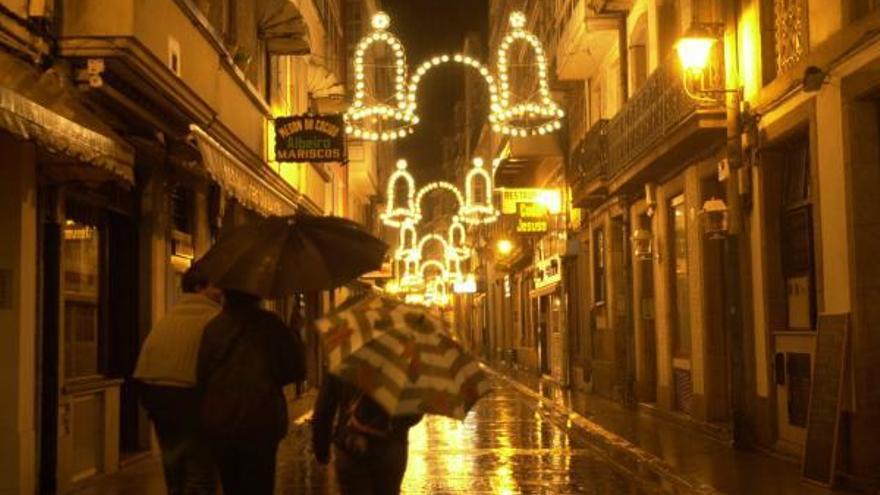Paraguas en una calle coruñesa con alumbrado navideño.