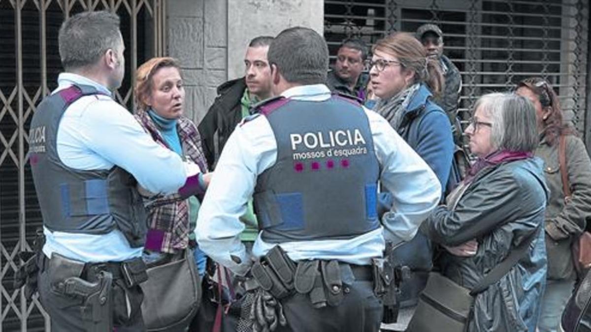 La mediadora Porta (con chaqueta granate) informa a dos Mossos de la situación de una familia de Nou Barris desahuciada.