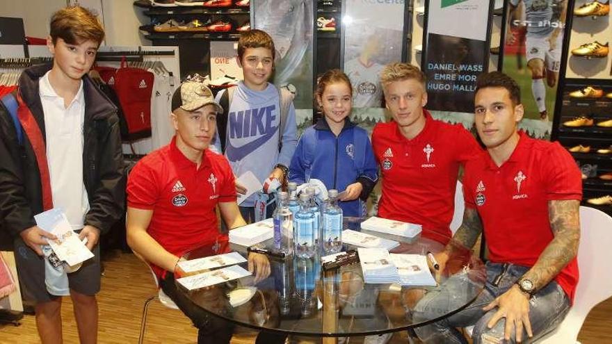 Emre Mor, Daniel Wass y Hugo Mallo con tres aficionados en El Corte Inglés. // A. Villar