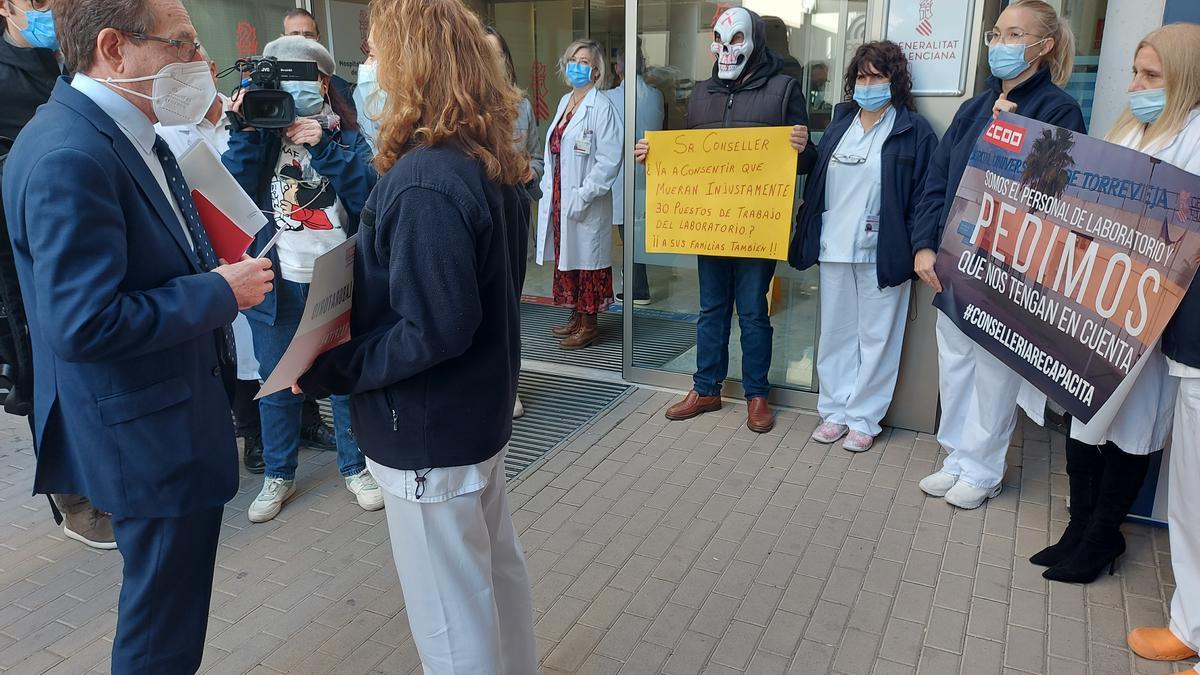 El conseller en la entrada del centro hospitalario ante las protestas de personal de laboratorio