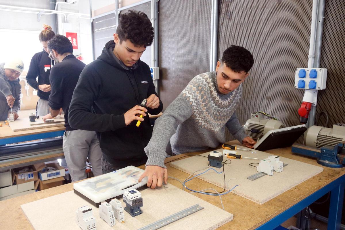 Joves que participen al programa fent pràctiques d'electricitat