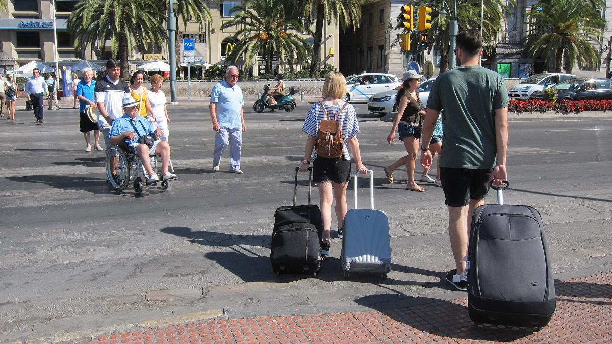 Turistas con sus maletas en el Centro de Málaga.