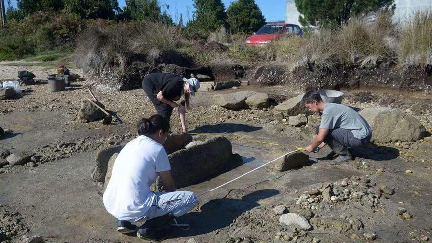 Los arqueólogos realizan mediciones en una de las cistas funerarias de Riasón. // Noé Parga