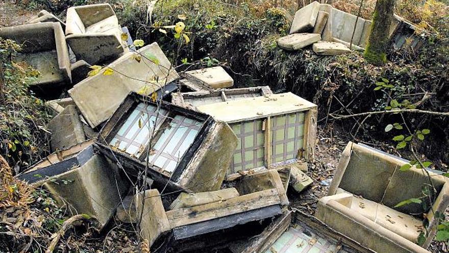 Vierten en un monte moañés una veintena de sofás rotos de la discoteca Salitre