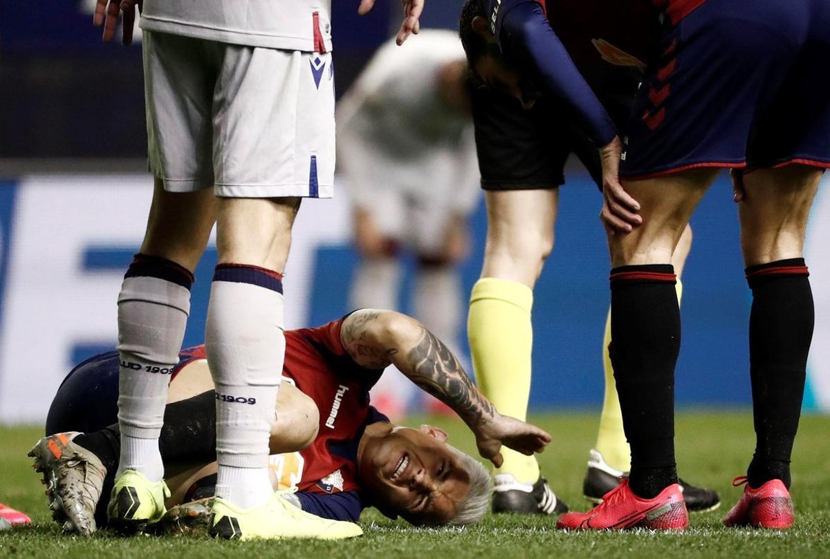 GRAF7716. PAMPLONA, 24/01/2020.- El delantero argentino de Osasuna, Luis Chimy Ávila, se duele en el terreno de juego tras caer lesionado durante el encuentro correspondiente a la jornada 21 de primera división que han disputado esta noche frente al Levante en el estadio de El Sadar, en Pamplona. EFE/Jesús Diges.