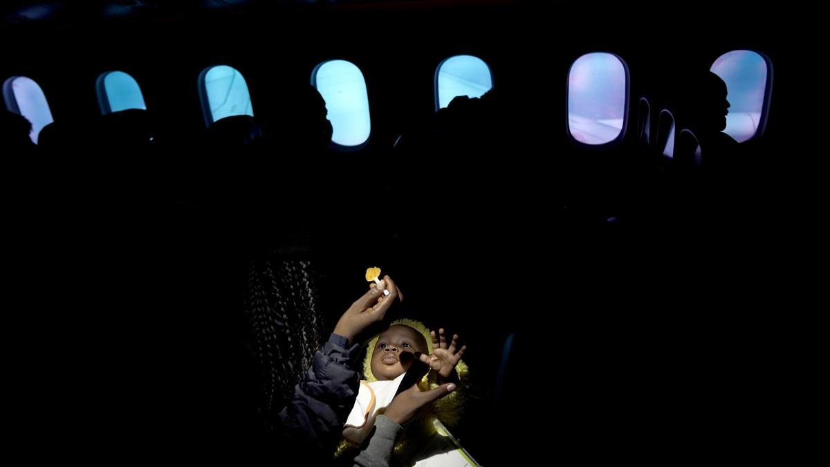 Una joven camerunesa alimenta a su bebé durante el vuelo. La mayoría de los refugiados eran mujeres y niños.