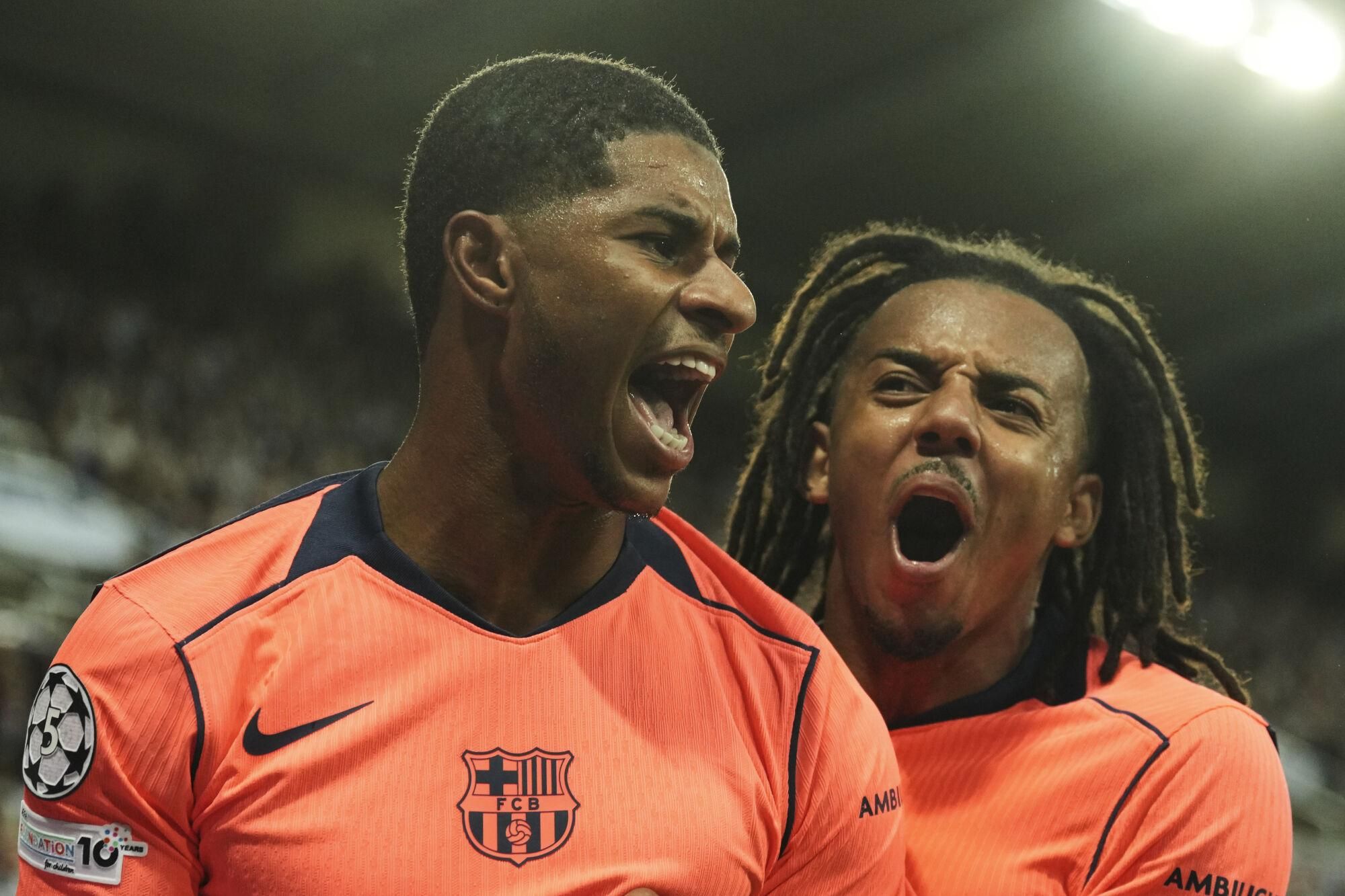 Barcelona's Marcus Rashford, left, celebrates after scoring his side second goal with Jules Kounde during the Champions League, opening phase soccer match between Newcastle and Barcelona in Newcastle, England, Thursday, Sept. 18, 2025. (AP Photo/Jon Super)