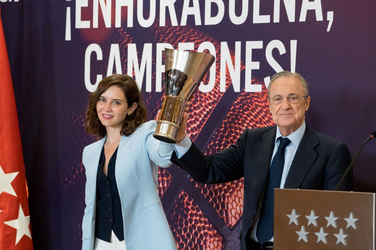 Florentino Pérez y Ayuso sujetan el trofeo de la Euroliga 2023 logrado por el Real Madrid de baloncesto.