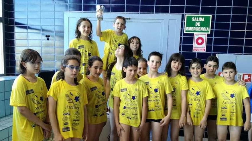 Los benjamines del CD Natación Zamora posan con el trofeo logrado en León y con la pancarta de sus patrocinadores.