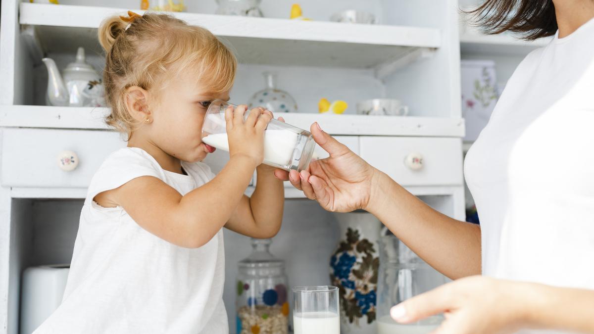Una niña tomándose un vaso de leche