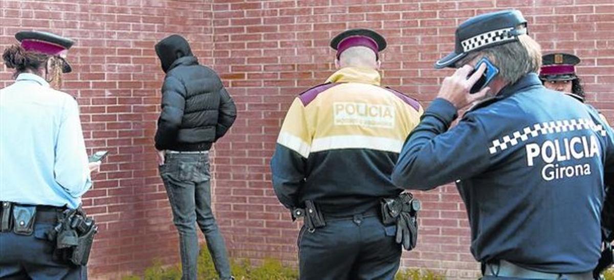 Agents dels Mossos amb un dels detinguts pels disturbis provocats a l’Escola d’Hostaleria, ahir a Girona.