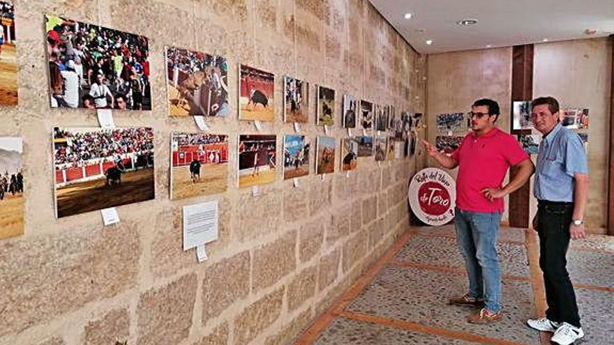 El alcalde, Tomás del Bien, y un aficionado observan las fotos.