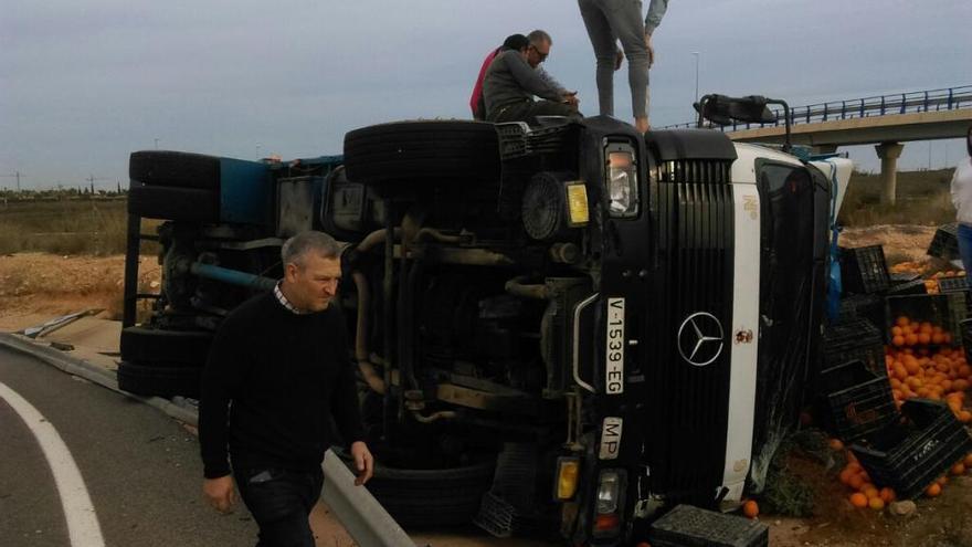 Rescatan a un hombre atrapado tras volcar el camión con naranjas que conducía en Pilar de la Horadada
