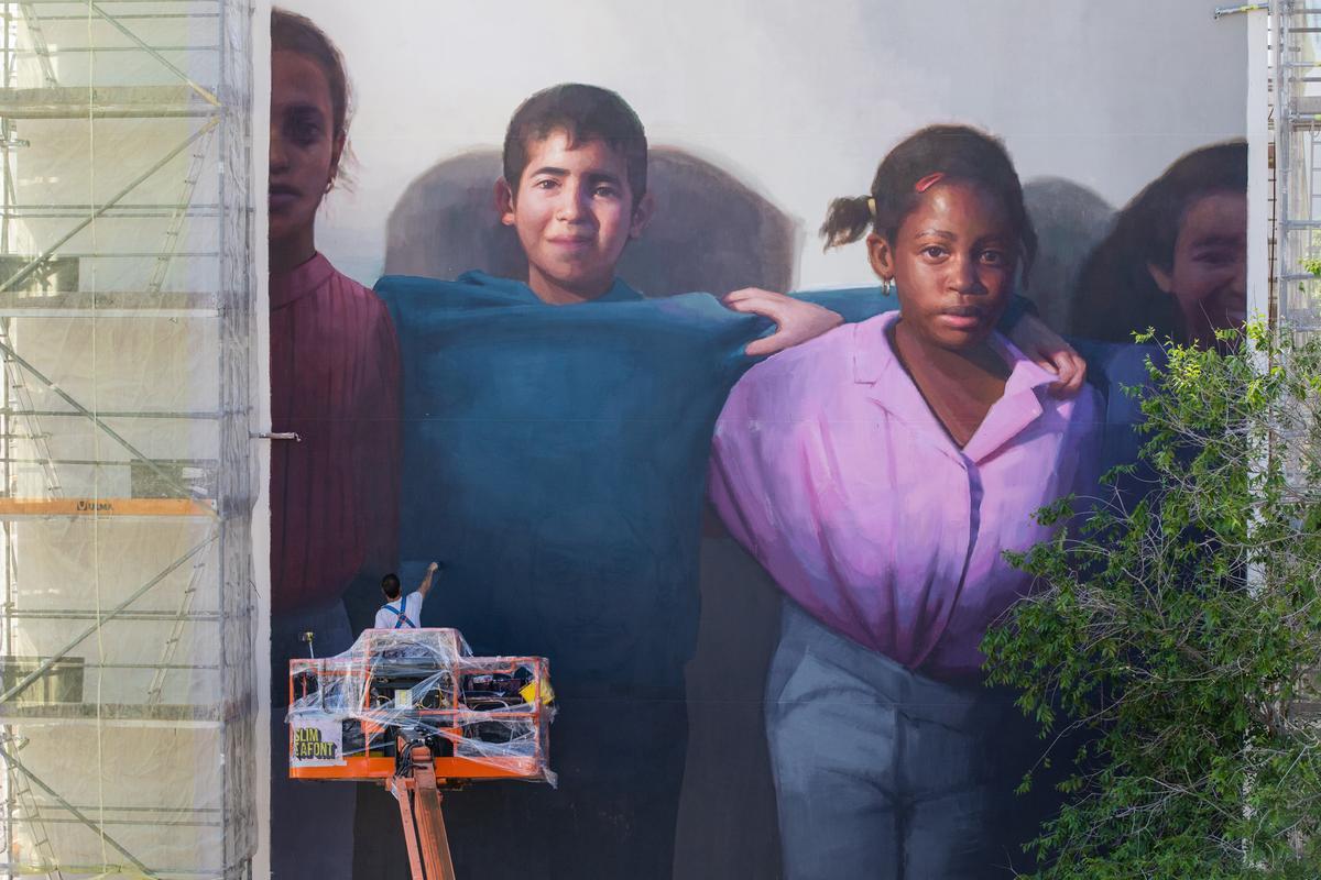 El artista Slim Safont rematando el mural 'La llum del barri' en el Besòs i el Maresme, en Barcelona.