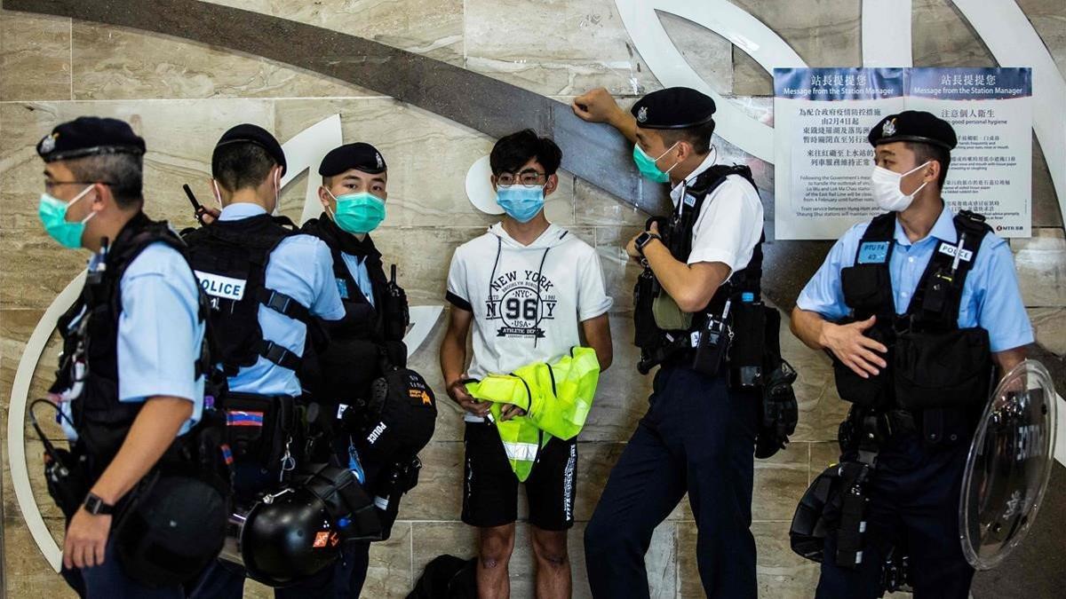 La policía retiene a un joven durante una protesta pro-democrática organizada en un centro comercial de Hong Kong.