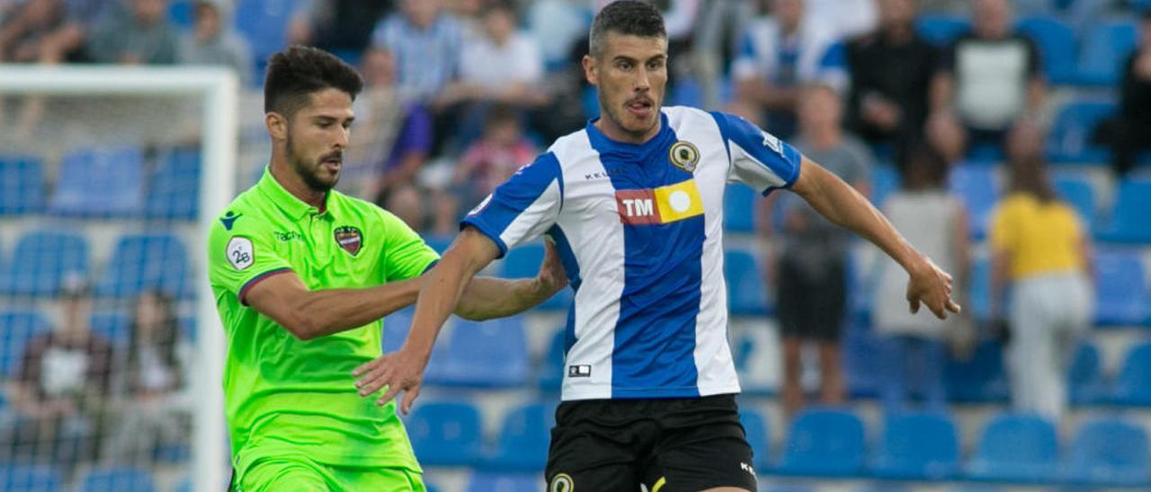 Pol Bueso conduce el balón ante Juan Delgado, en el Hércules-Atlético Levante.