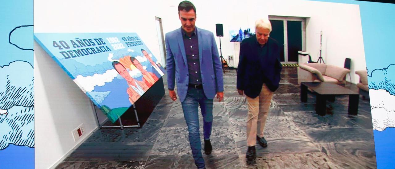 Felipe González y Pedro Sánchez llegan juntos al mitin del 40º aniversario de la victoria del PSOE en España. En la imagen, los militantes miran un vídeo donde aparecen ambos a su llegada.