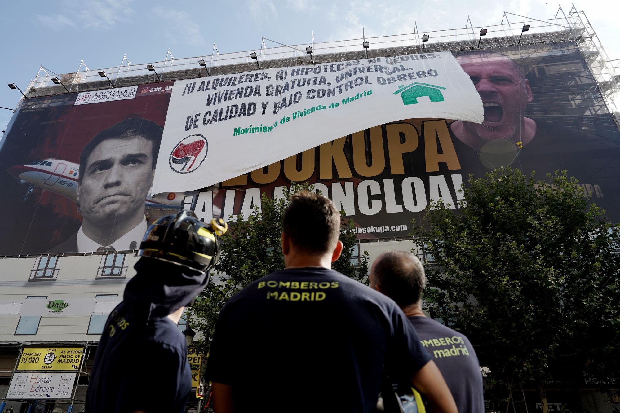 La colocación de una pancarta sobre la lona de Desokupa en Madrid, en imágenes