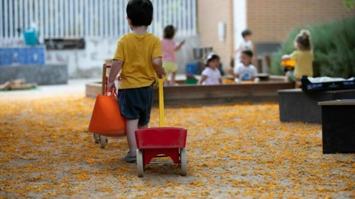 Un niño juega con una carretilla en una guardería municipal.