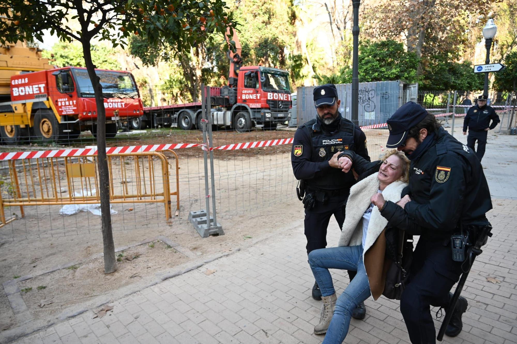 Una señora entra en el recinto vallado y es retirada por agentes de la Policía Nacional.