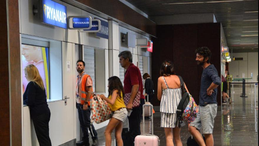 Pasajeros frente a la oficina de Ryanair en el aeropuerto de Gando.