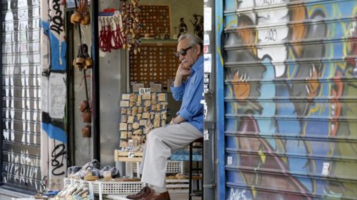 Espera 8 Un vendedor aguarda pacientemente a la llegada de clientes en el área céntrica de Atenas.