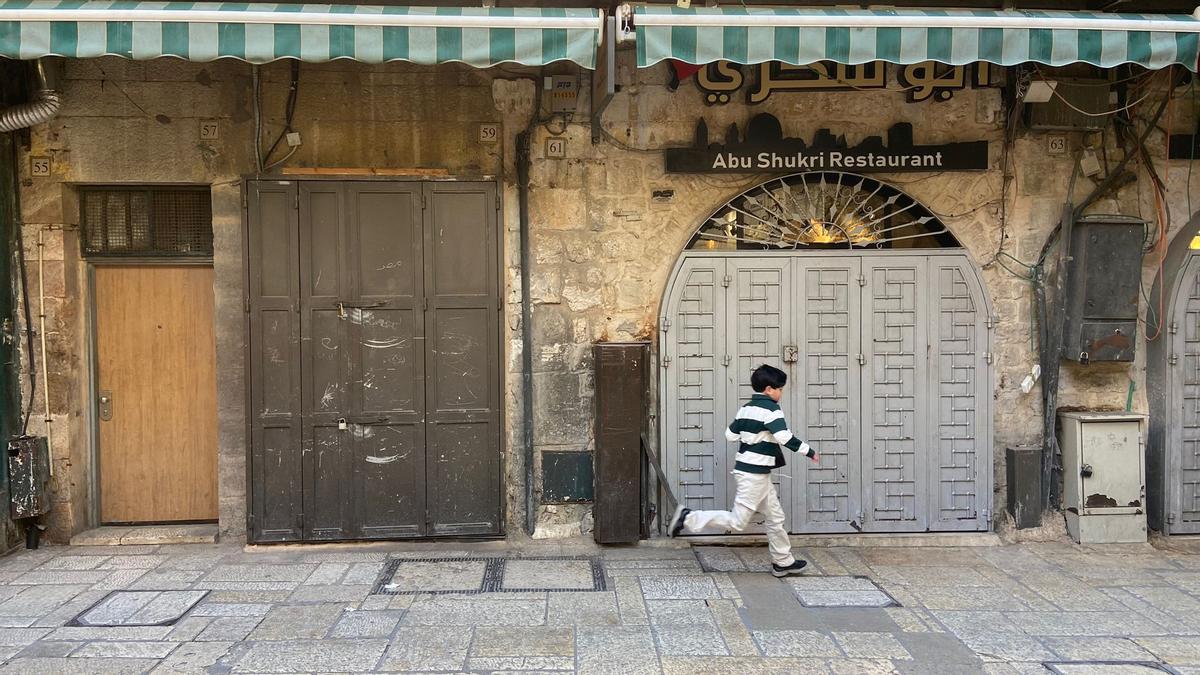 Un niño corre por las desiertas calles de la ciudad vieja de Jerusalén
