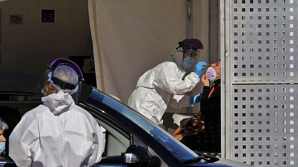 Dos sanitarias realizan pruebas PCR en el hospital de campaña de La Fe de València.