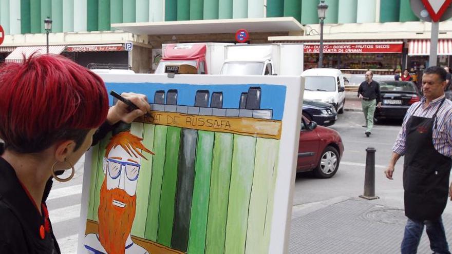Una artista pinta frente a Mercado de Russafa, ayer.