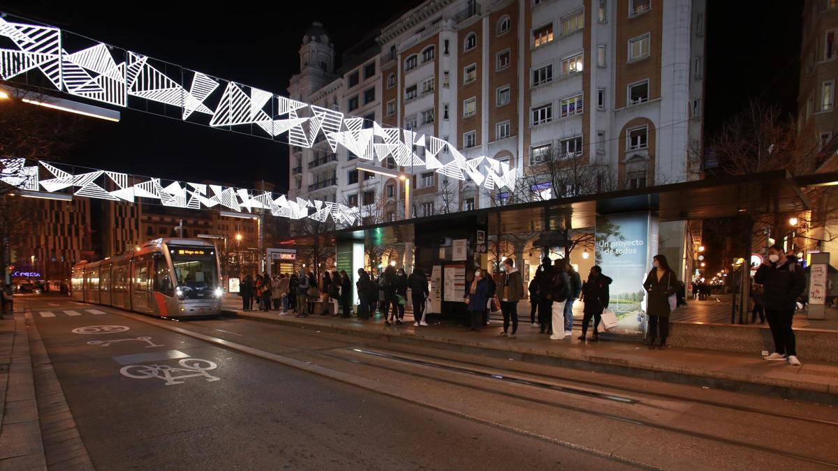 Usuarios del tranvía de Zaragoza esperando en la parada de la plaza España.