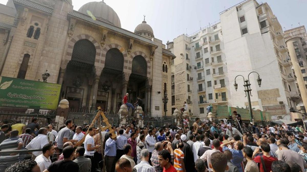 Simpatizantes de los Hermanos Musulmanes y policías, ante la mezquita de El Cairo donde se han atrincherado los islamistas, este sábado.