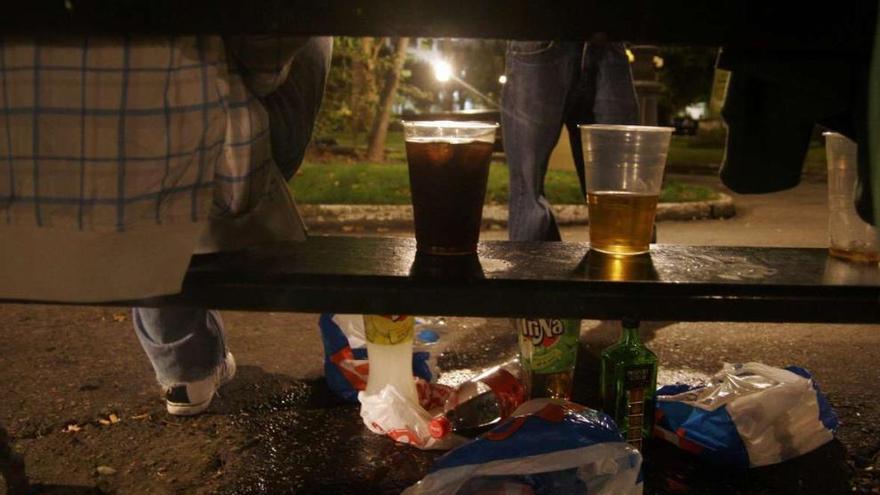 Un joven sentado en un banco durante un &#039;botellón&#039;. casteleiro