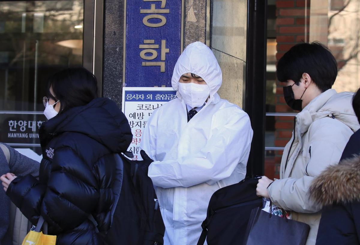 Seoul (Korea, Republic Of), 23/02/2020.- A quarantine official guides those taking the Certified Public Accountant exam into the testing site at Hanyang University in Seoul, South Korea, 23 February 2020. South Korea reported 556 cases of novel coronavirus, accounting for the second largest number of infections outside mainland China. Public gatherings were banned in the capital while the southeastern cities of Daegu and Cheongdo were declared ’special care zones’ after a cluster of COVID-19 cases was reported in the region in recent days. The outbreak has so far killed nearly 2,500 people and infected over 78,000 others worldwide, mostly in China. (Corea del Sur, Seúl) EFE/EPA/YONHAP SOUTH KOREA OUT