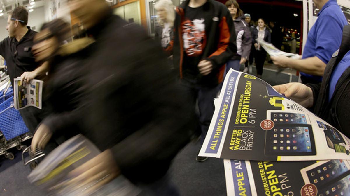 Compradores con folletos sobre el 'black friday' en Nueva York.